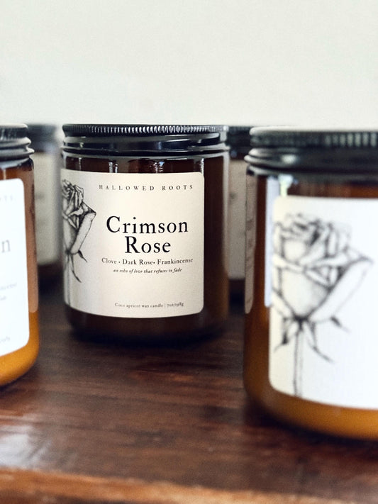 Jars of 'Crimson Rose' on a wooden surface with a white background