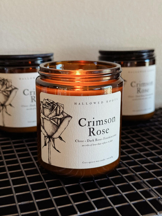 Candle labeled 'Crimson Rose' with a rose illustration on a metal grid.