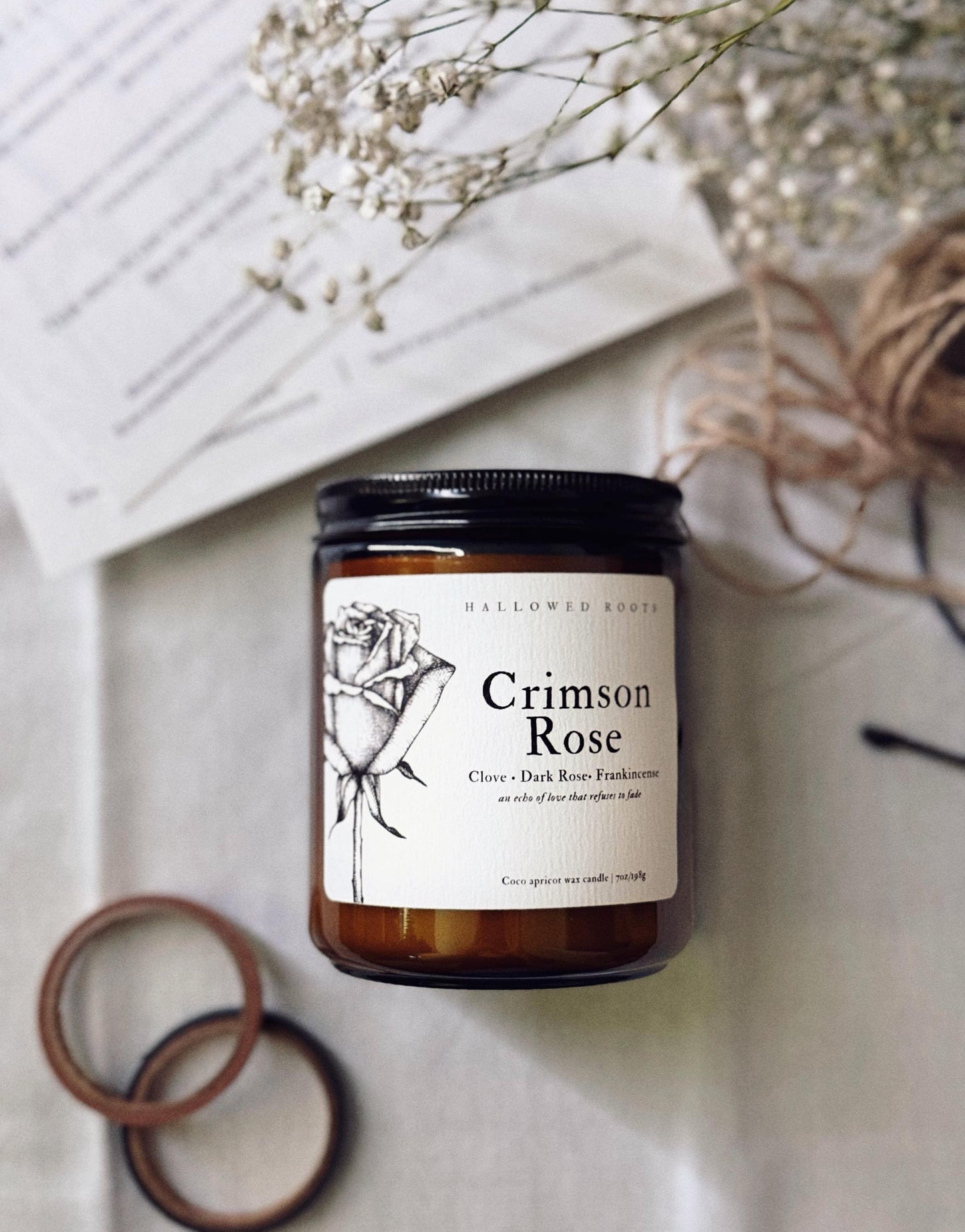 Candle labeled 'Crimson Rose' on a neutral background with decorative elements.